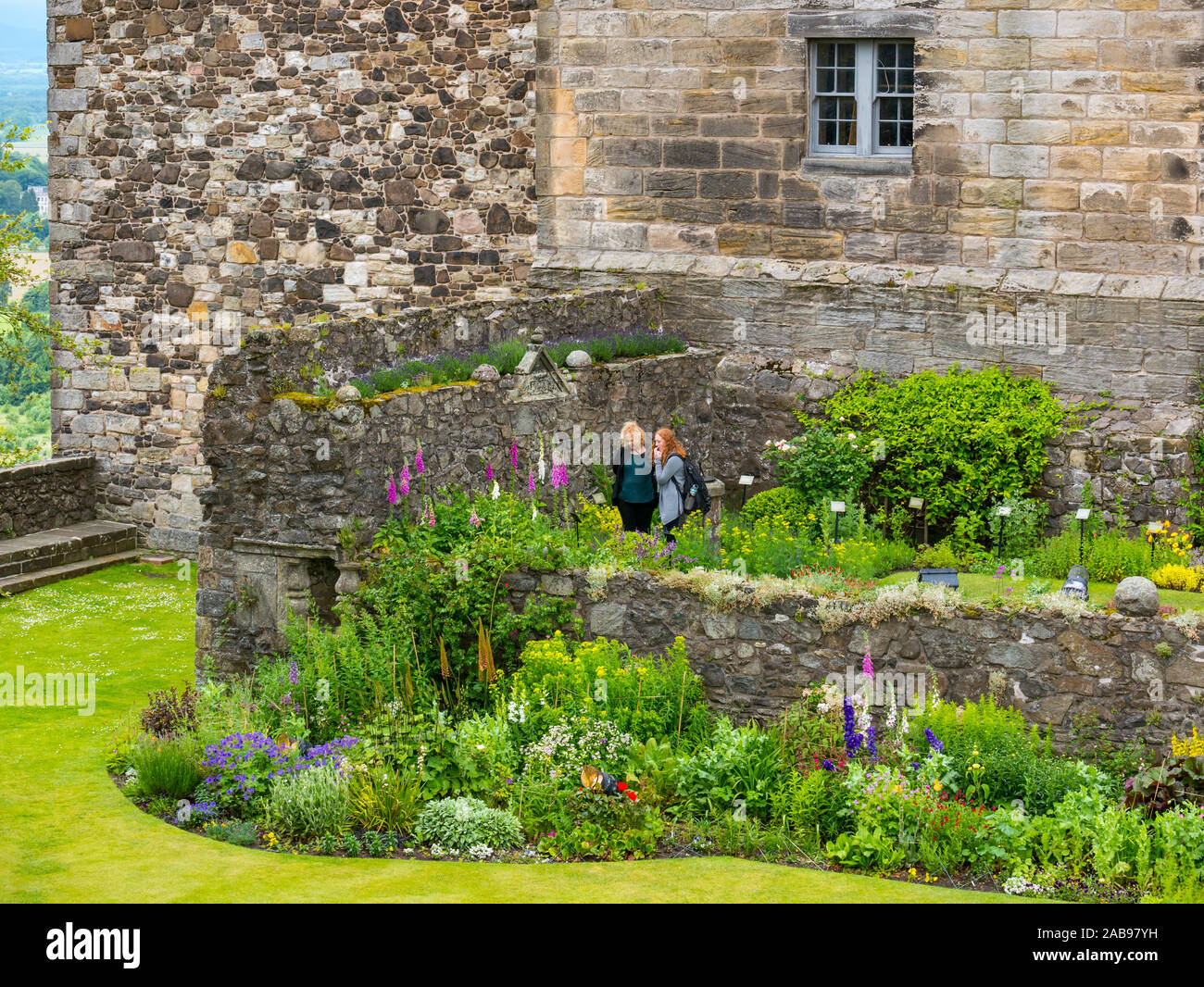 Women or female tourists looking at flowers in Queen Anne Garden and palace, Stirling Castle, Scotland, UK Stock Photo