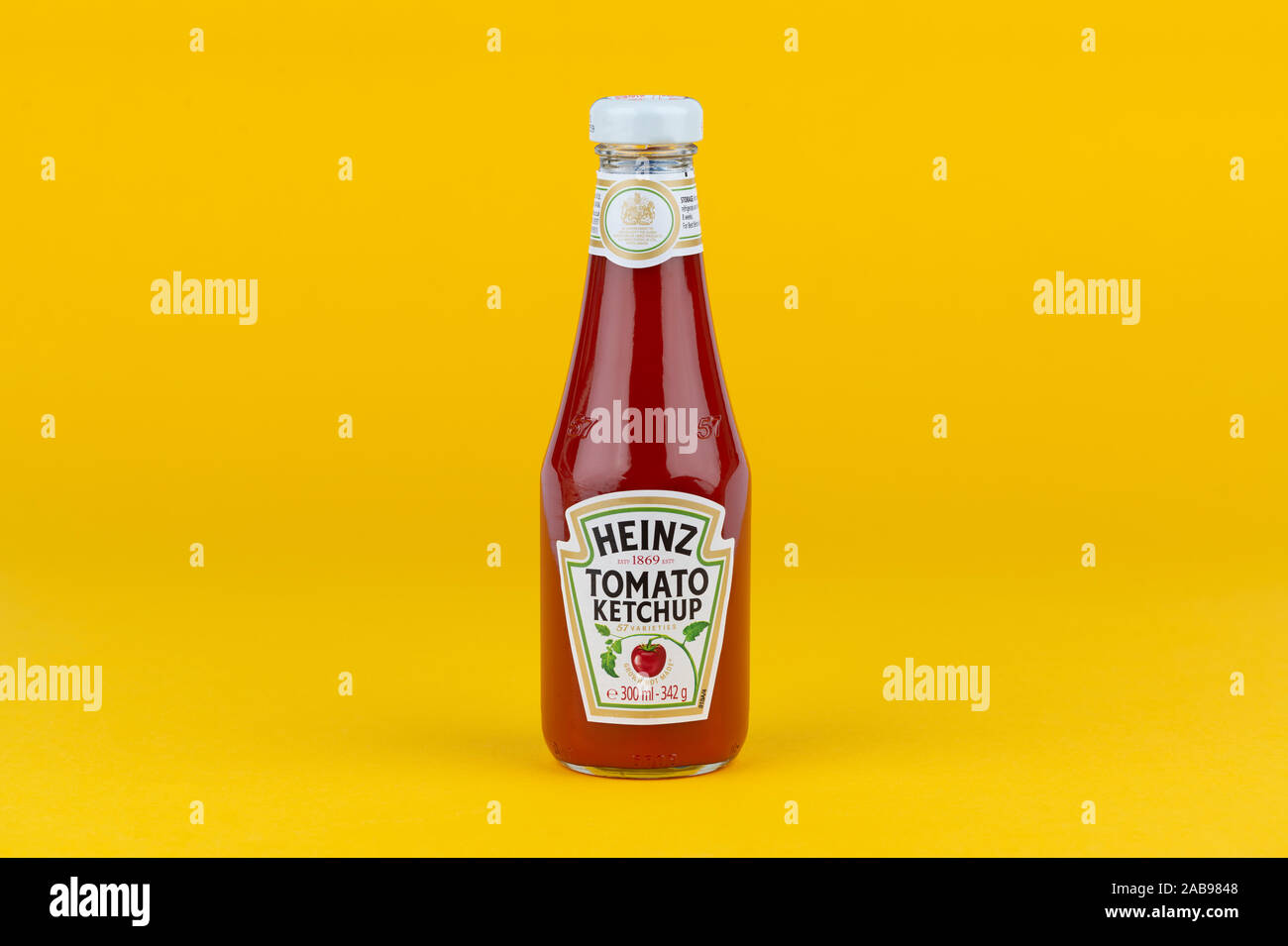 A bottle of Heinz Tomato Ketchup shot on a yellow background. Stock Photo