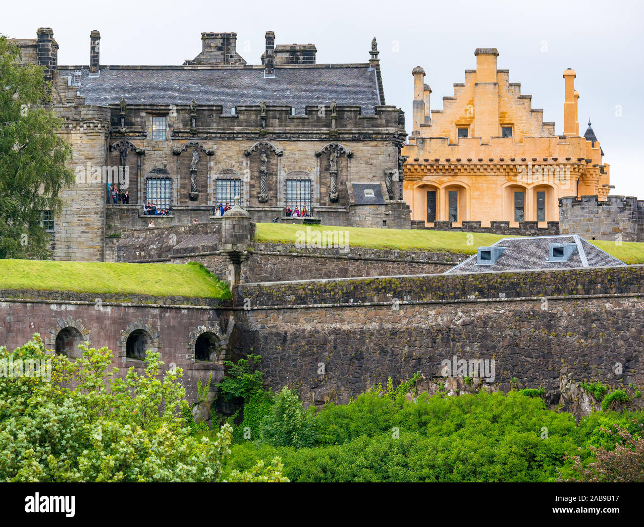 Tourists on battlements of Stirling Castle with yellow lime wash Great Hall Scotland UK Stock Photo Alamy