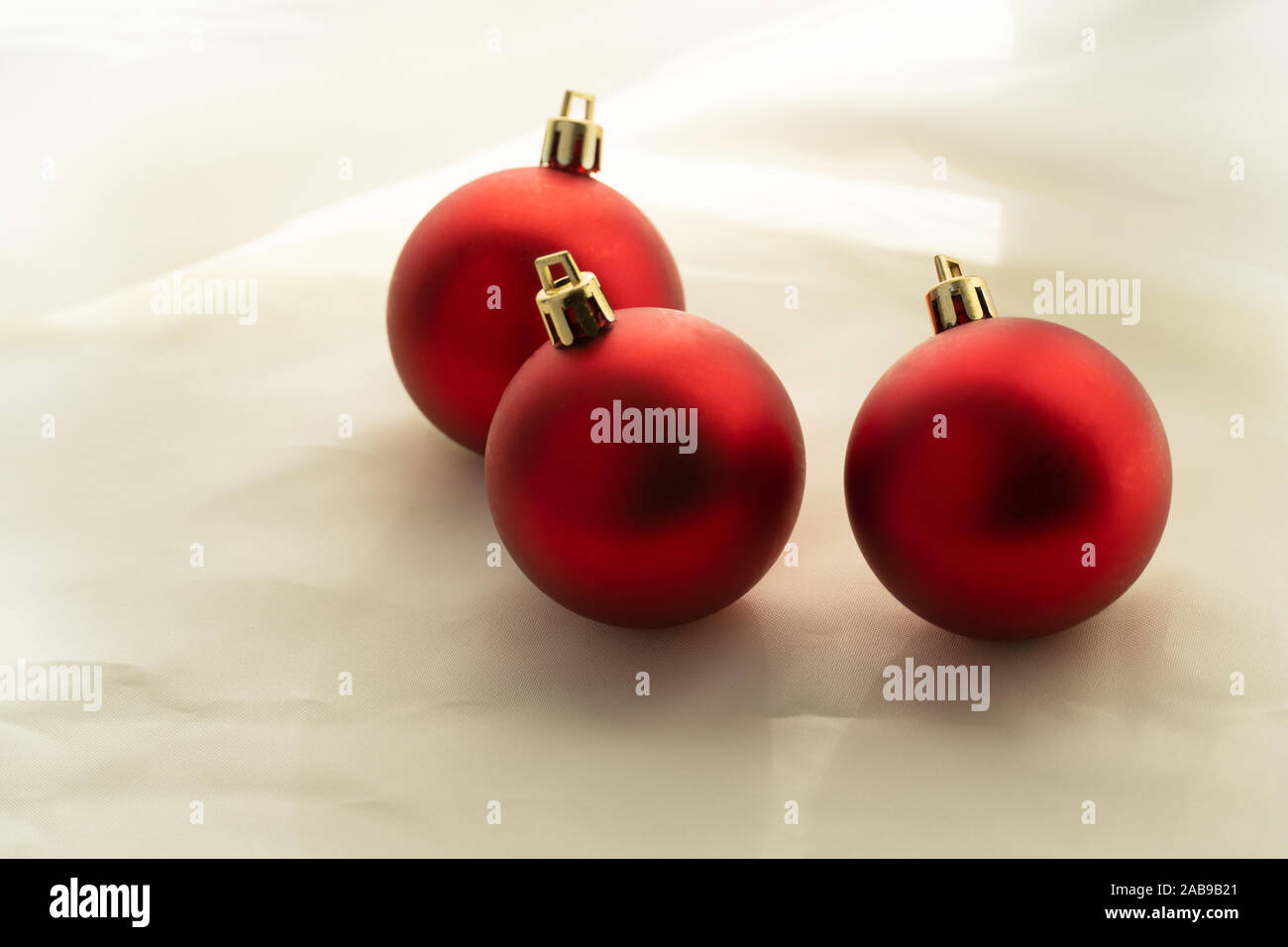 three red round Christmas ball for decoration on soft white fabric background Stock Photo