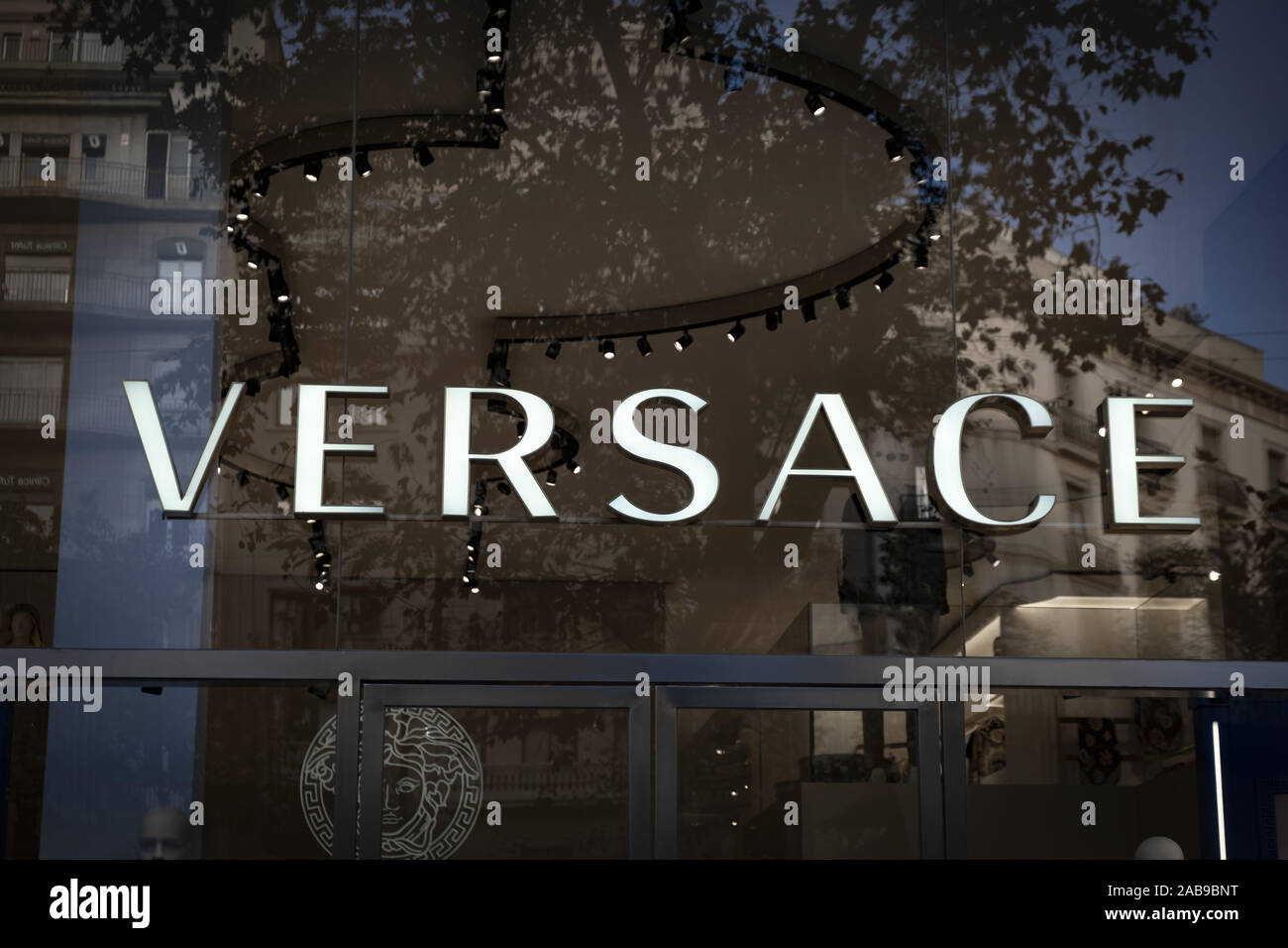 The logo of VERSACE, an Italian company specializing in the design and  marketing of clothing and accessories, seen at the Passeig de Gràcia  store.A boulevard of just over a kilometre, the Passeig