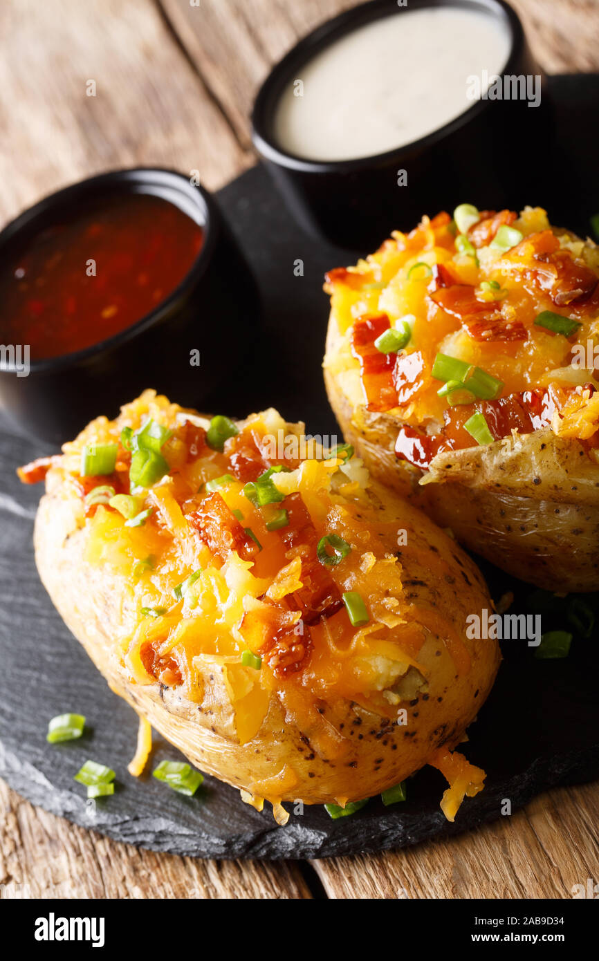 Baked potatoes stuffed with cheddar cheese and bacon closeup on the