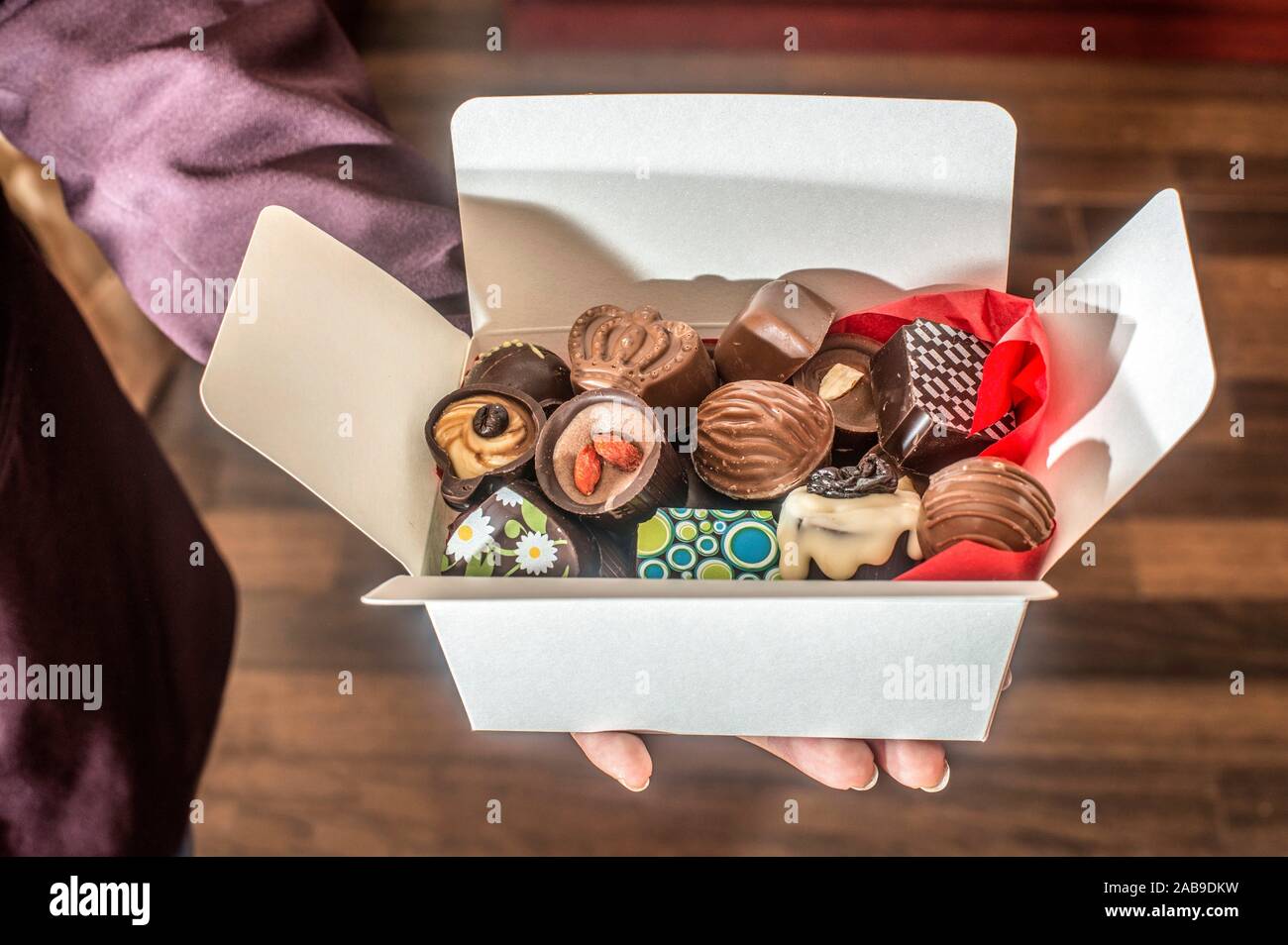 Hands holding a box of chocolates. Close up Stock Photo Alamy