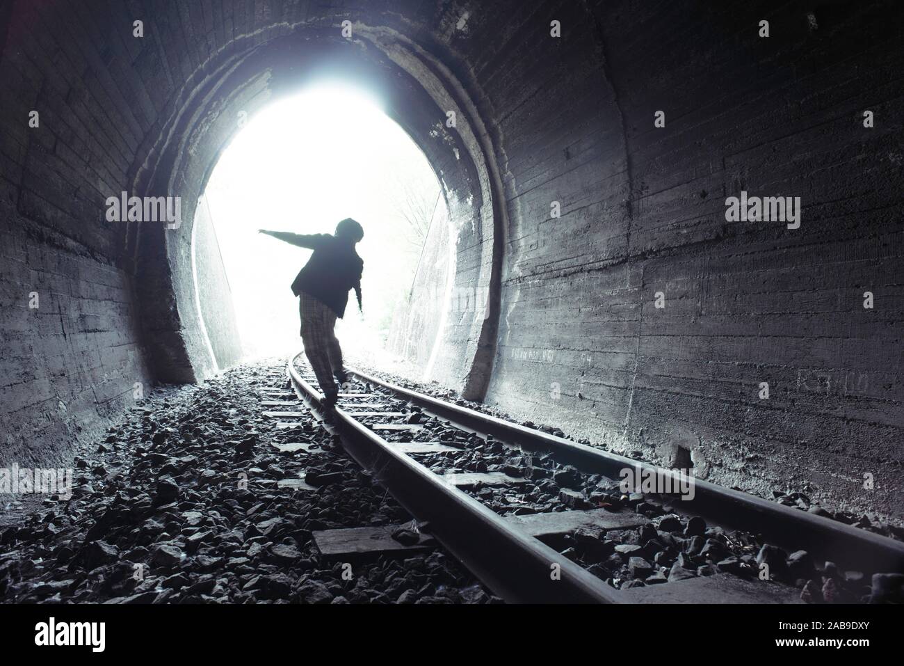 Child walking in railway tunnel. Vintage clothes. Stock Photo