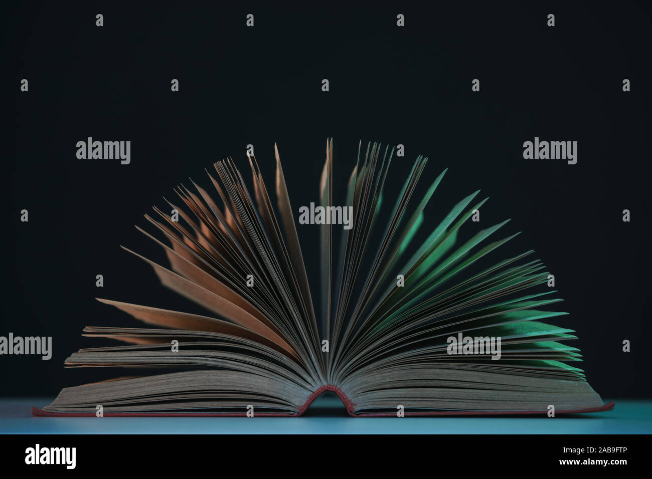 Open Book Colour Beautiful open book pages in the color neon light on a table and night ...