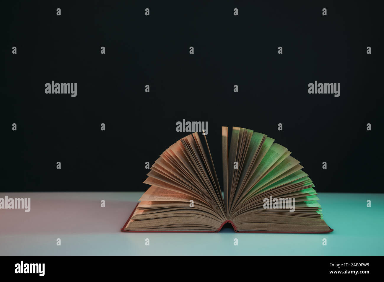 Open Book Colour Beautiful open book pages in the color neon light on a table and night ...