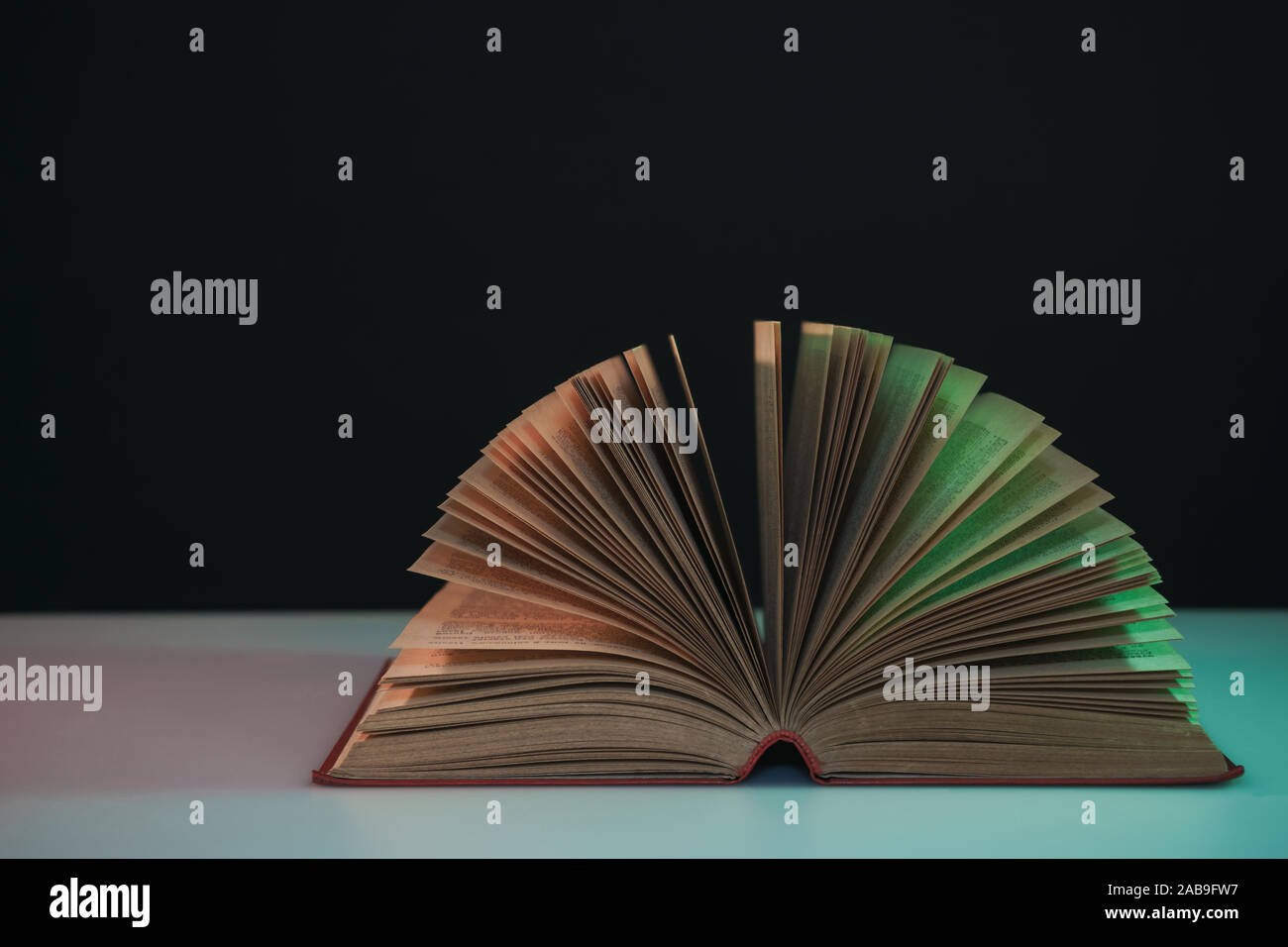 Open Book Colour Beautiful open book pages in the color neon light on a table and night ...