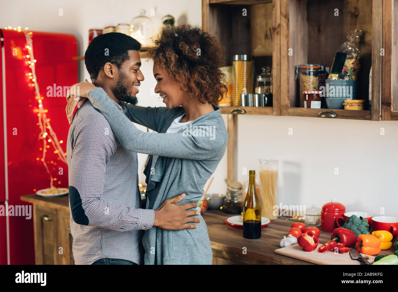 Lovely black couple embracing in cozy kitchen Stock Photo