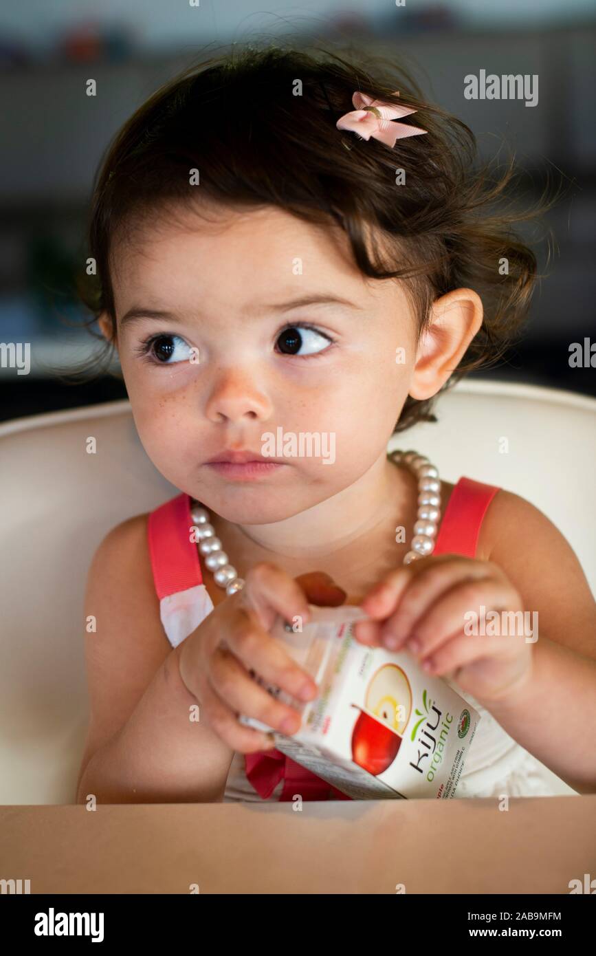 Two year old girl drinking fruit juice Stock Photo Alamy