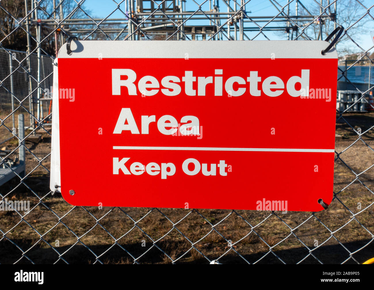 Restricted Area Keep Out red and white sign on fence at construction site. Stock Photo