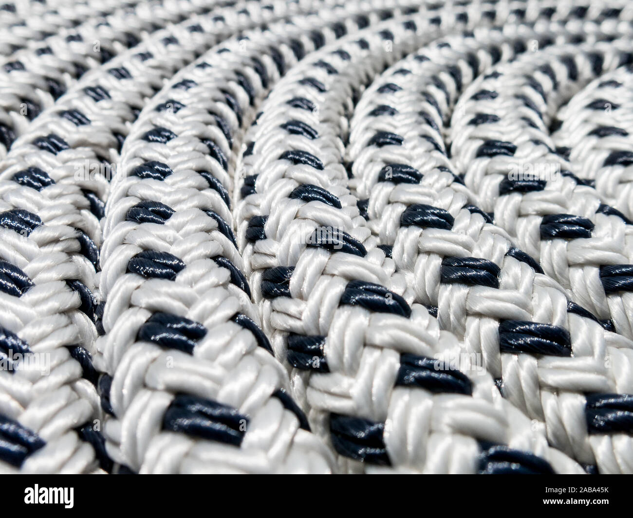 Close-up of braided polyester black and white marine rope coiled in a circle Stock Photo