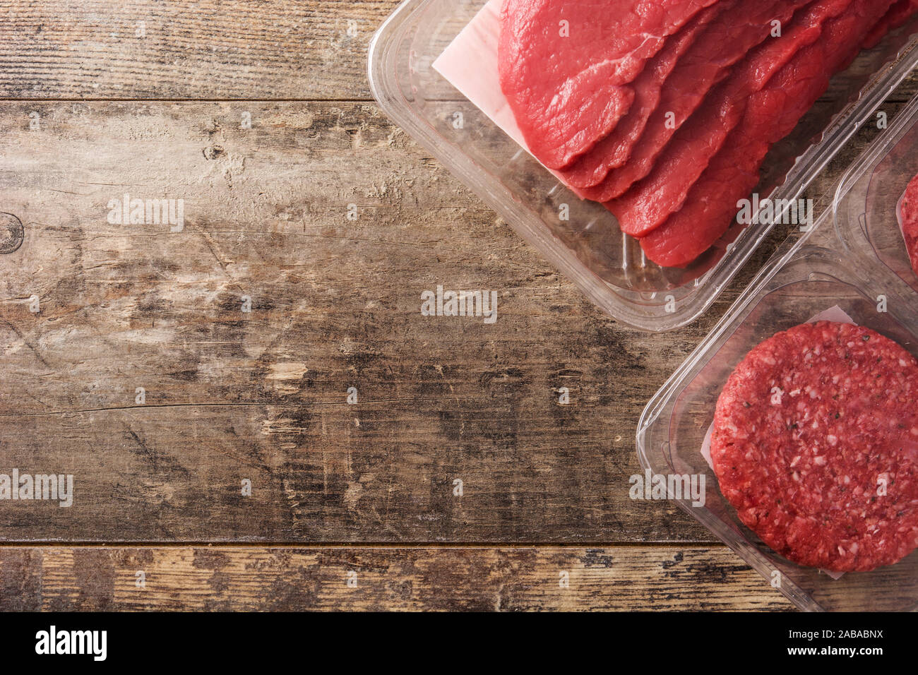 Different types of meat packaged in plastic on wooden table. Top view Stock Photo