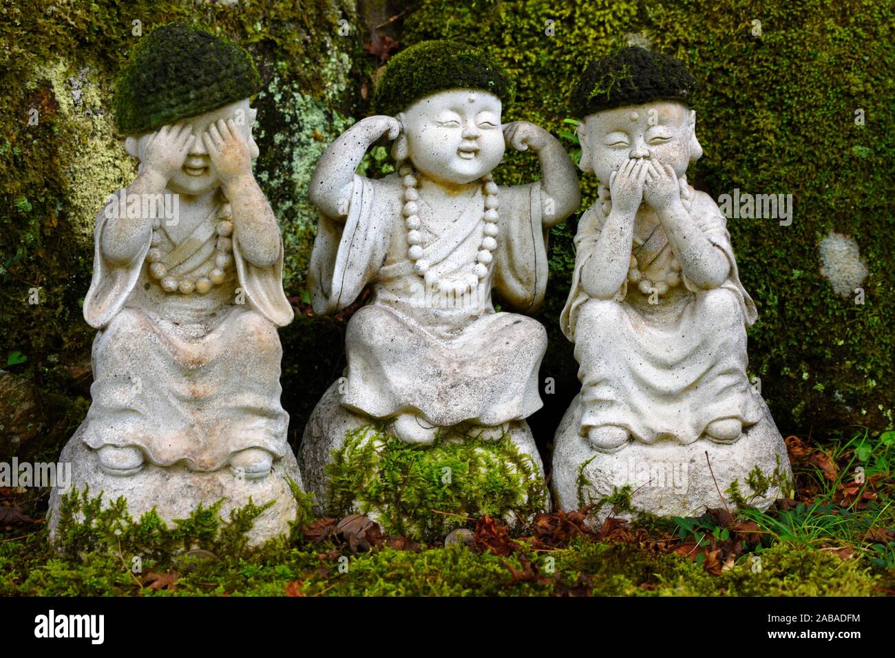 Group of three stone statues of buddhistic monks holding their eyes