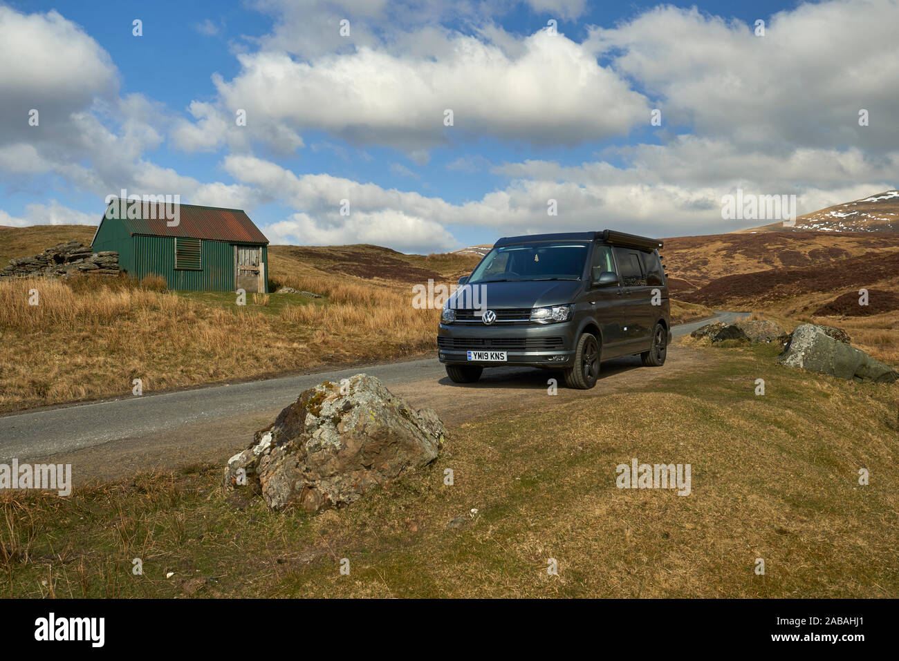 VW Campervan parked in passing place on a remote and pretty road in the ...