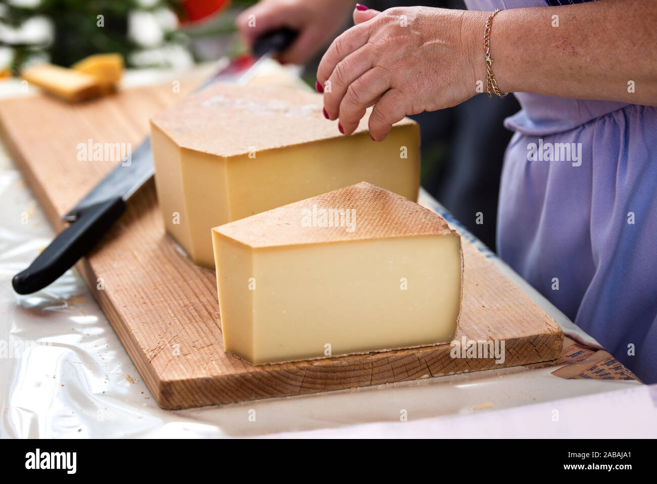 woman is saling swiss gruyere cheese in the market of Charmey, Fribourg, switzerland Stock Photo