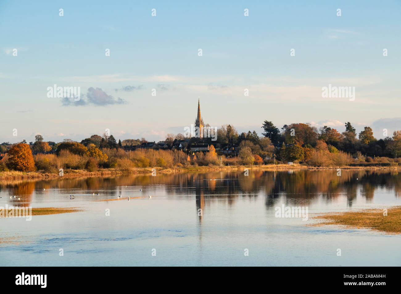 Kings sutton church reflected in flood water across the cherwell valley in autumn. Kings Sutton, Nr Banbury, Northamptonshire, England Stock Photo