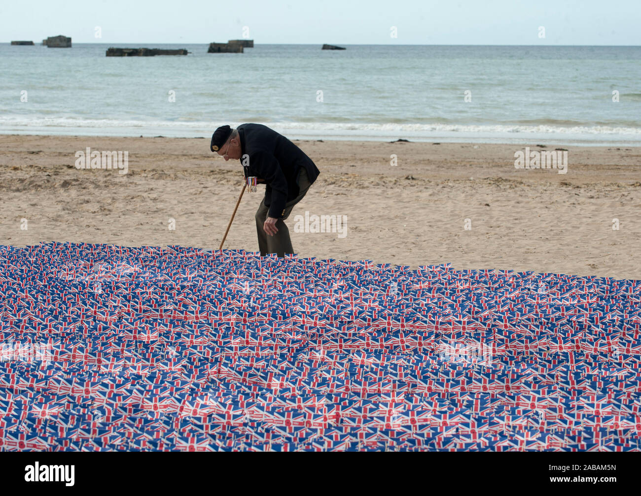 Cyril Ager a sapper from the Royal Engineers who landed on this beach 'Gold Beach' D-Day plus half hour planting a flag in remembrance for the D- Day celebrations. June 5th 2014. Stock Photo