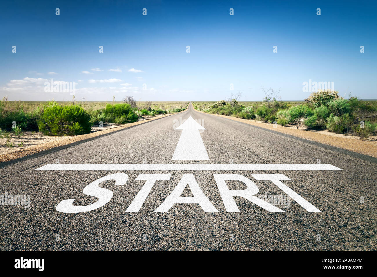 Eine unendlich lange Strasse mit der wegweisenden Aufschrift: "Start" Stock Photo