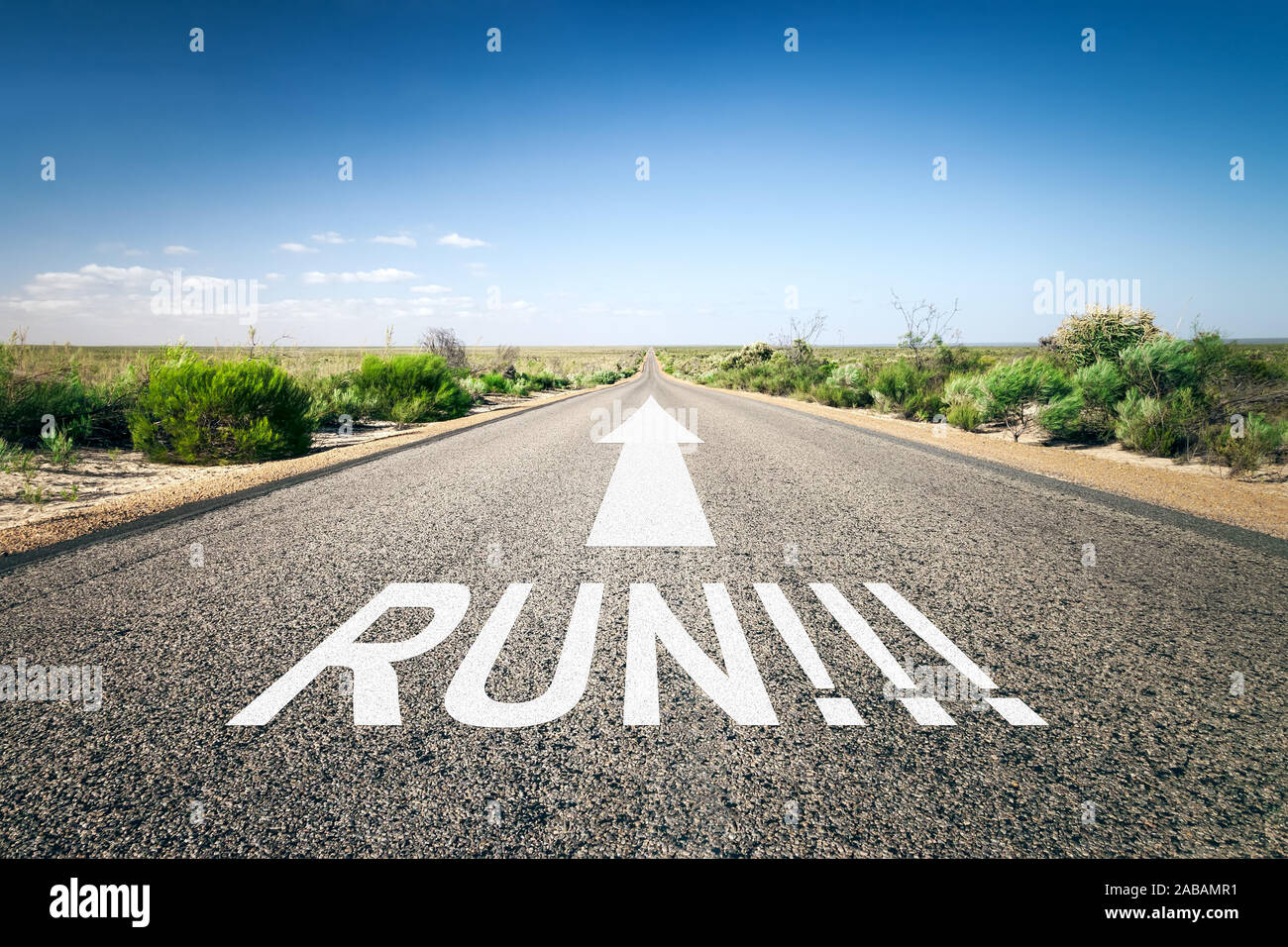 Eine unendlich lange Strasse mit der wegweisenden Aufschrift: 'Run!' Stock Photo