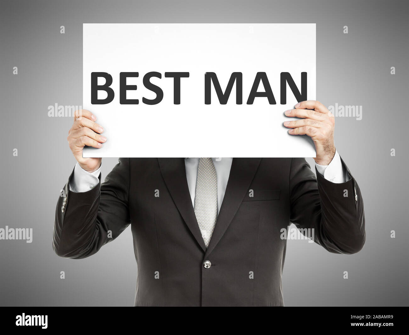 Ein Geschaeftsmann, der ein Schild mit den Worten 'Best Man' in der Hand haelt Stock Photo