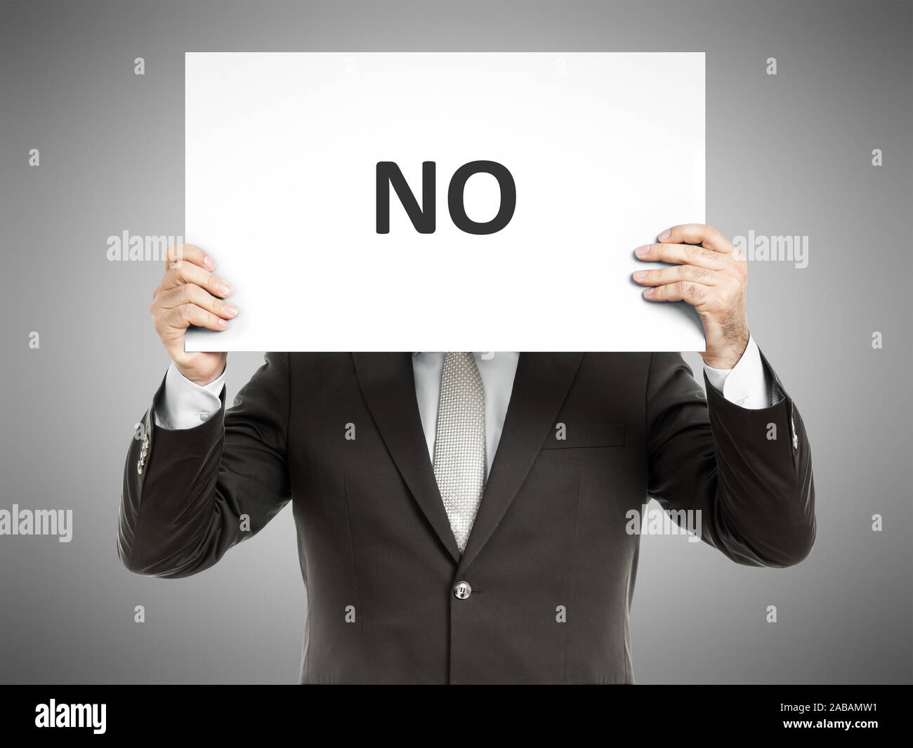 Ein Geschaeftsmann, der ein Schild mit den Worten "No" in der Hand haelt Stock Photo
