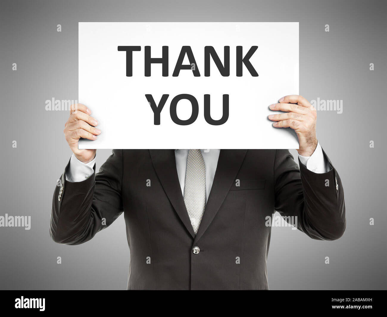 Ein Geschaeftsmann, der ein Schild mit den Worten 'Thank You' in der Hand haelt Stock Photo