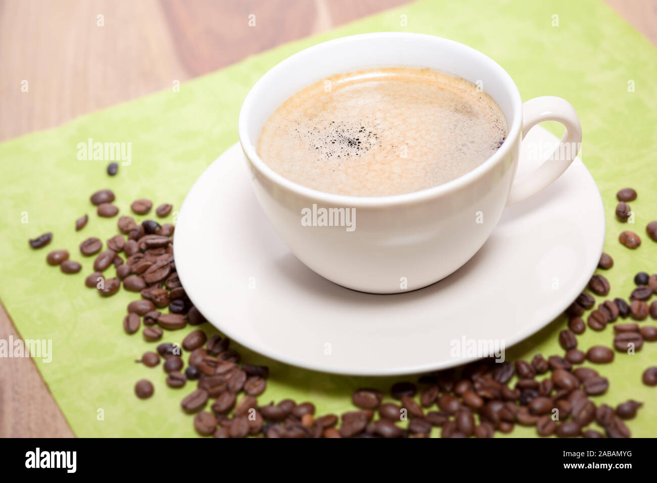 Eine Kaffeetasse, die von Kaffeebohnen umgeben ist Stock Photo