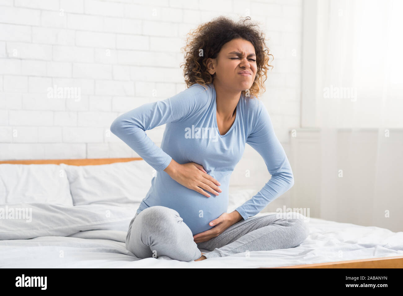 Labor contractions. Pregnant woman having pain in belly Stock Photo