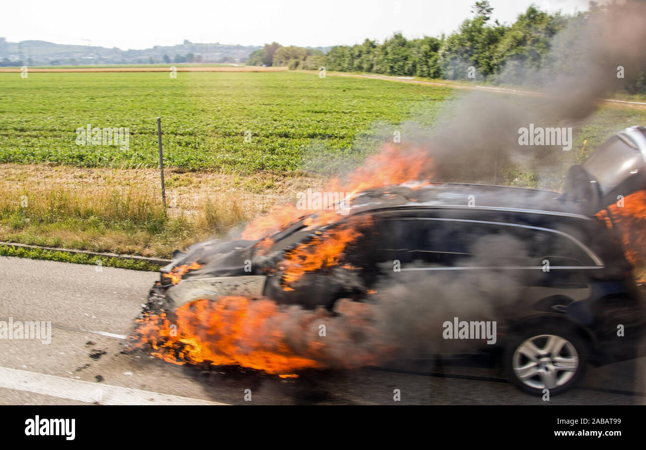 Brennendes Fahrzeug am Strassenrand ohne Personenschaden. Stock Photo