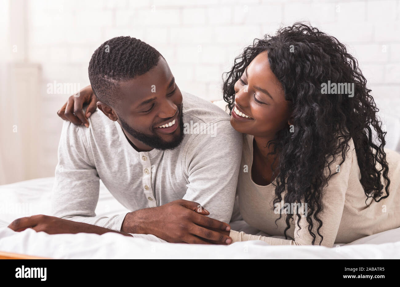 Romantic african american couple cuddling on bed at home Stock Photo