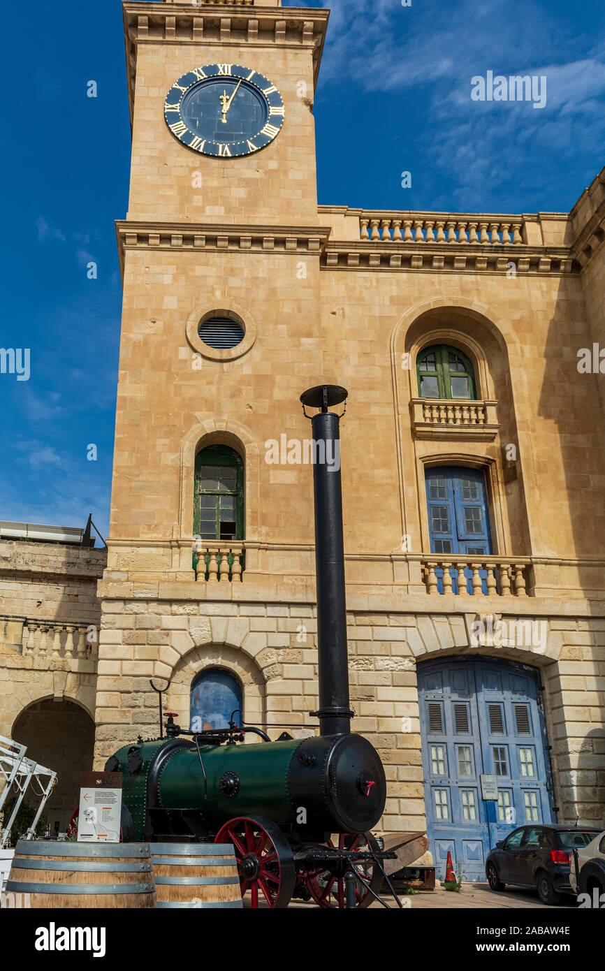 Clock tower of Malta Maritime Museum with old steam engine in front Stock Photo