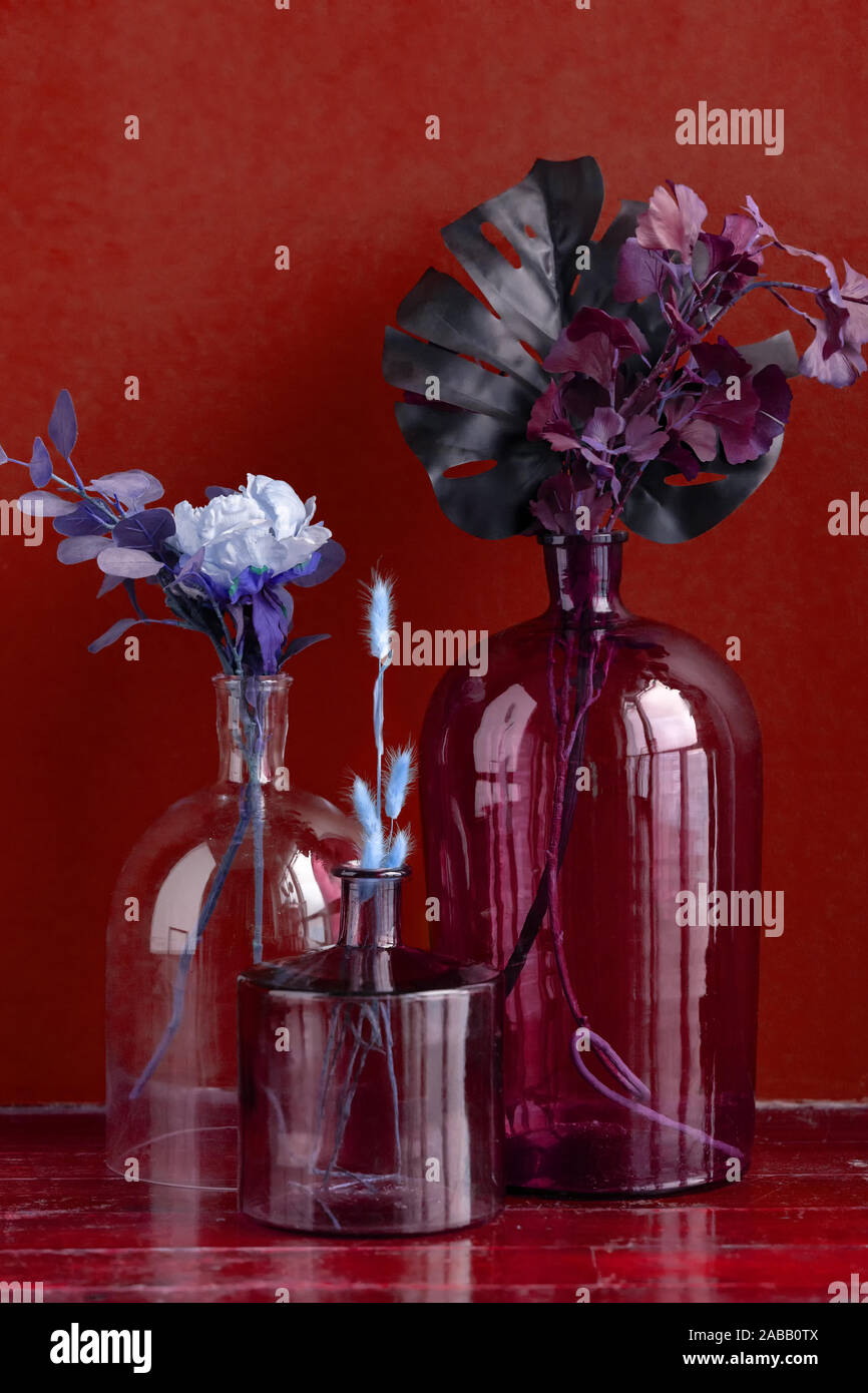 Various Artificial Flowers And Dry Plants In Transparent Vases On