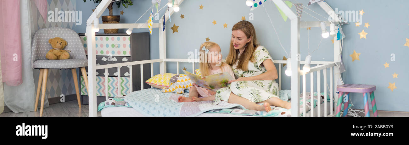 Cute 3 Years Old Girl And Her Young Mother Are Reading A