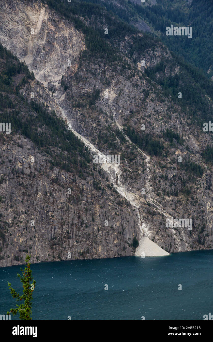 Landslide off a rocky mountain into Anderson Lake during a cloudy