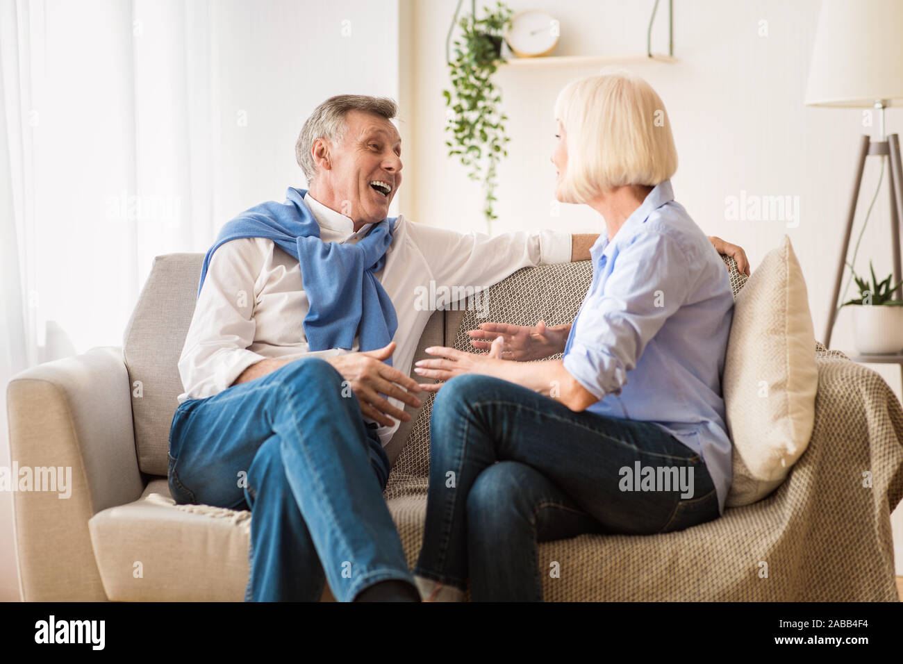 Happy senior spouses talking, enjoying conversation and joking Stock Photo