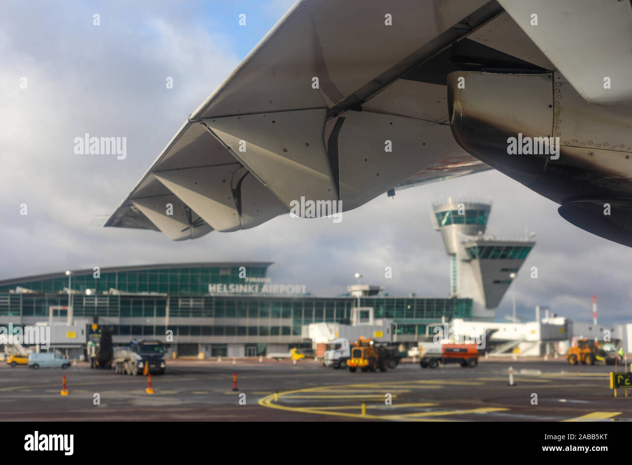 Helsinki Airport framed by airplane wing, selective focus Stock Photo