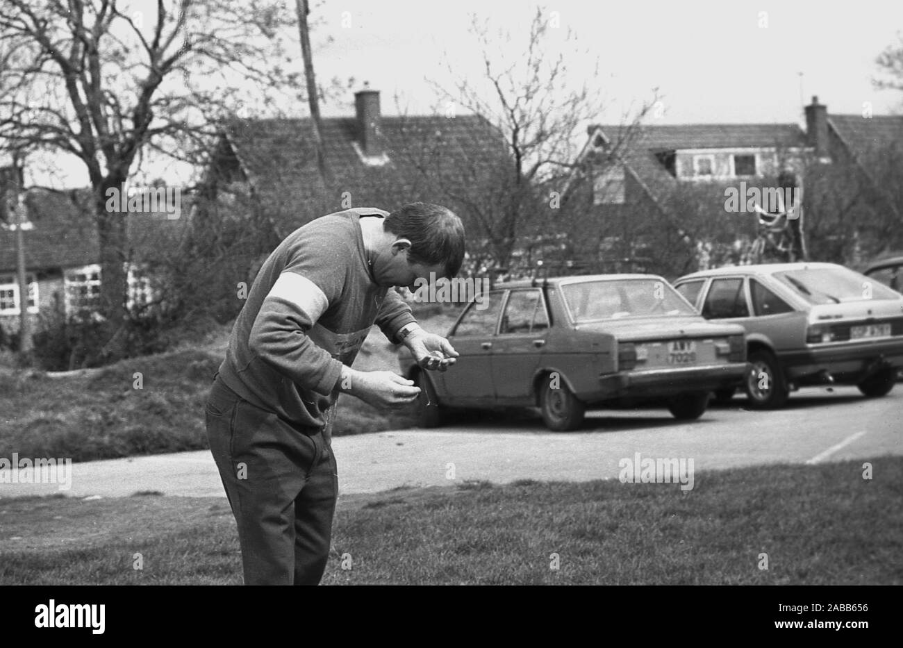 1980s, historical, a man taking part in a traditional egg throwing competition gets a splattering when the egg he has just caught breaks open over his clothes, England, UK. Egg throwing is a two person sport requiring distance lobbing and the ability to catch the delicate object. Each team member begins by standing ten metres apart, spreading out after each successful catch. But....drop or break the egg and you are out!  It is believed that egg throwing first occurred in the 1300s, gradually becoming an informal sport called the 'egg toss', played at country fairs and fetes. Stock Photo