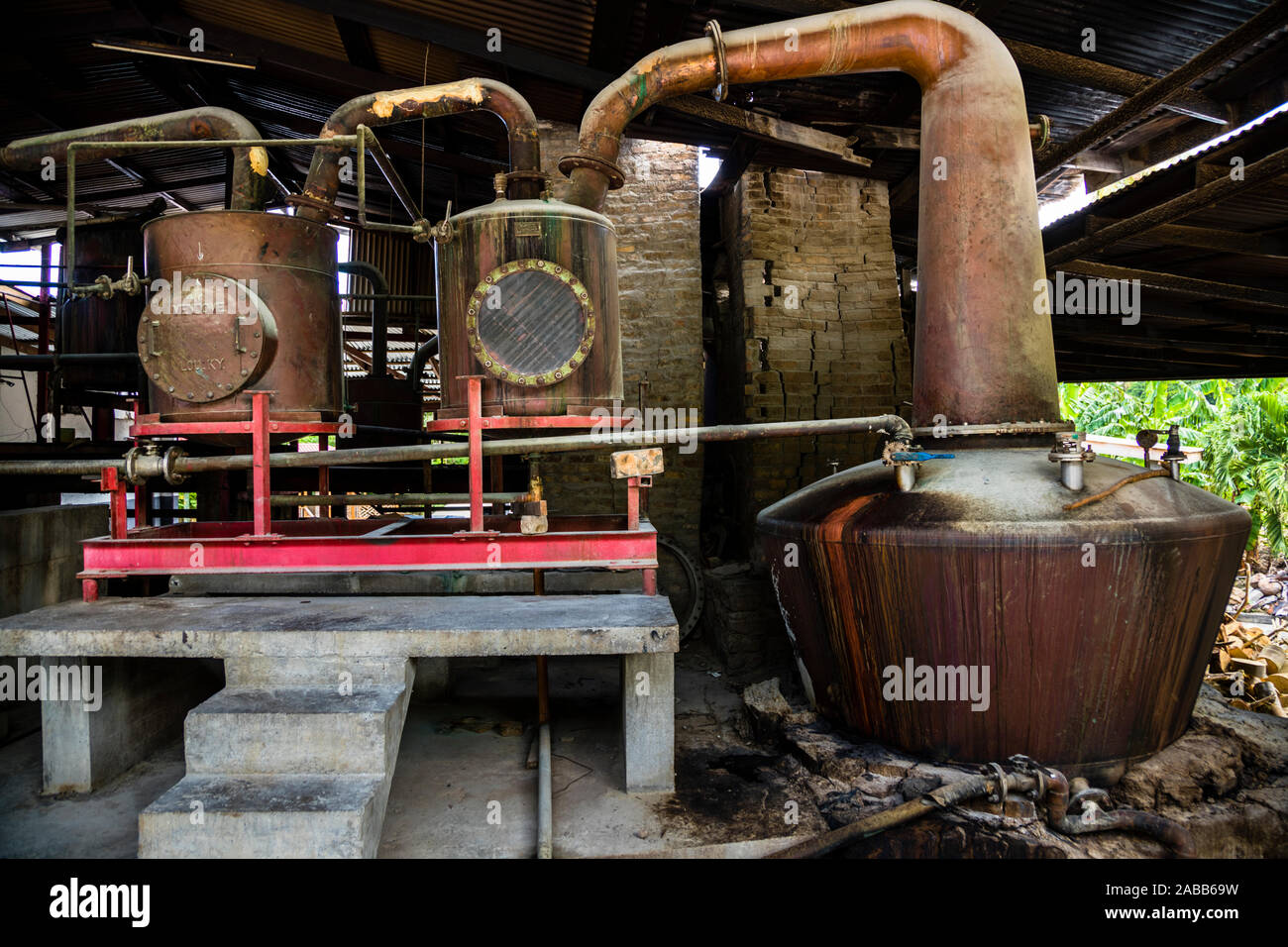 Antoine Rivers Rum Distillery, Saint Patrick, Grenada. Only a concrete platform was subsequently built under the intercoolers. The vessels of the distillation column still have the shape from the founding year 1785 Stock Photo