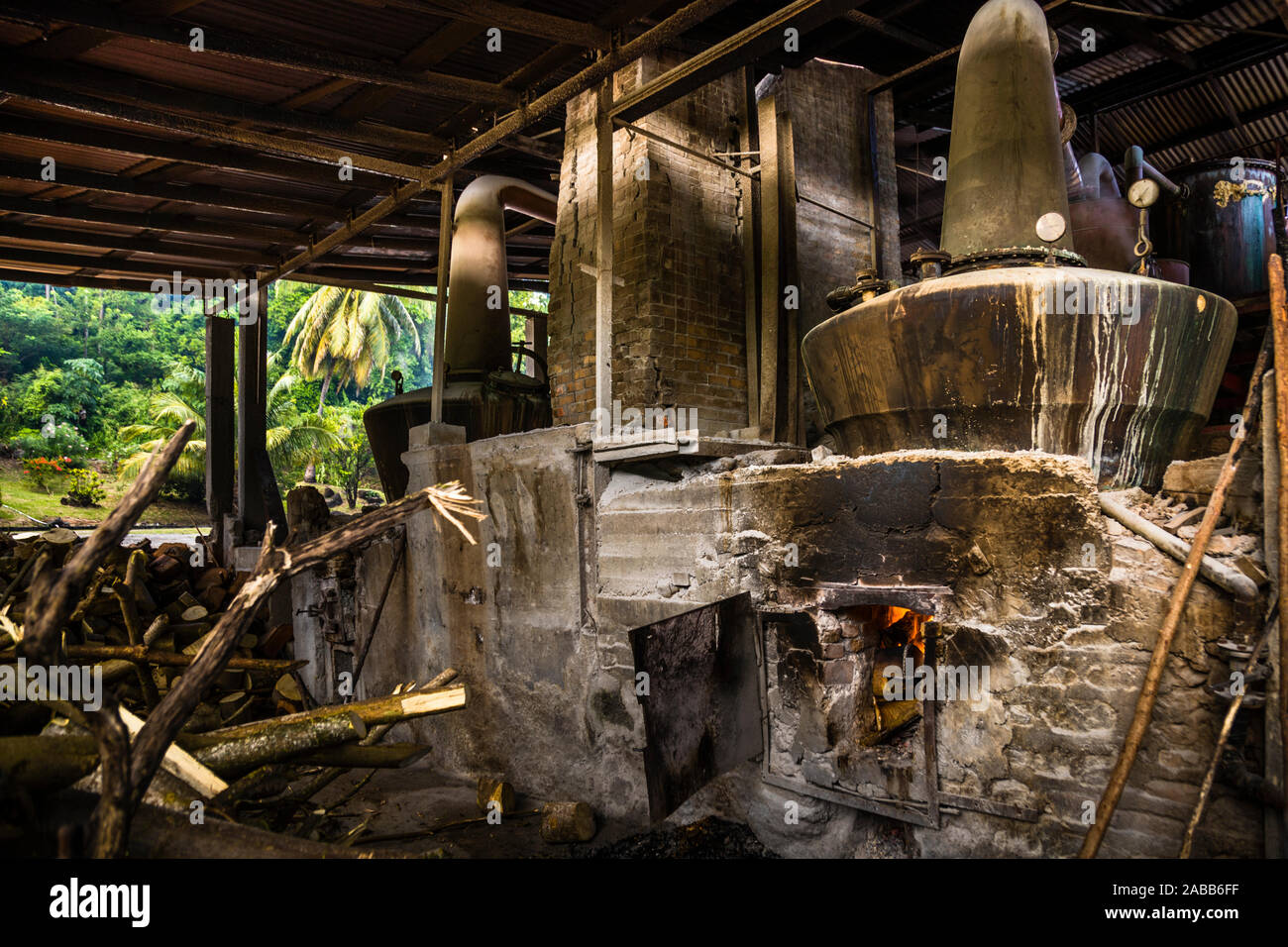 Antoine Rivers Rum Distillery, Saint Patrick, Grenada. The wood fire blazes under the boiling flask. The ancient safety regulations are probably still sufficient Stock Photo