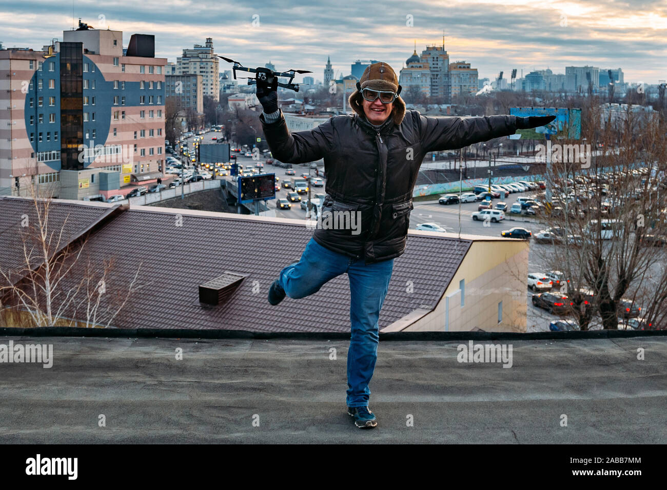 Young happy hipster man with drone in hands on the roof. Stock Photo
