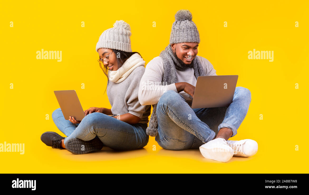 Friendly african couple using laptops, sitting on floor Stock Photo
