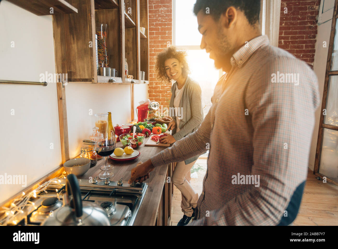 Happy african-american couple cooking dinner in kitchen Stock Photo