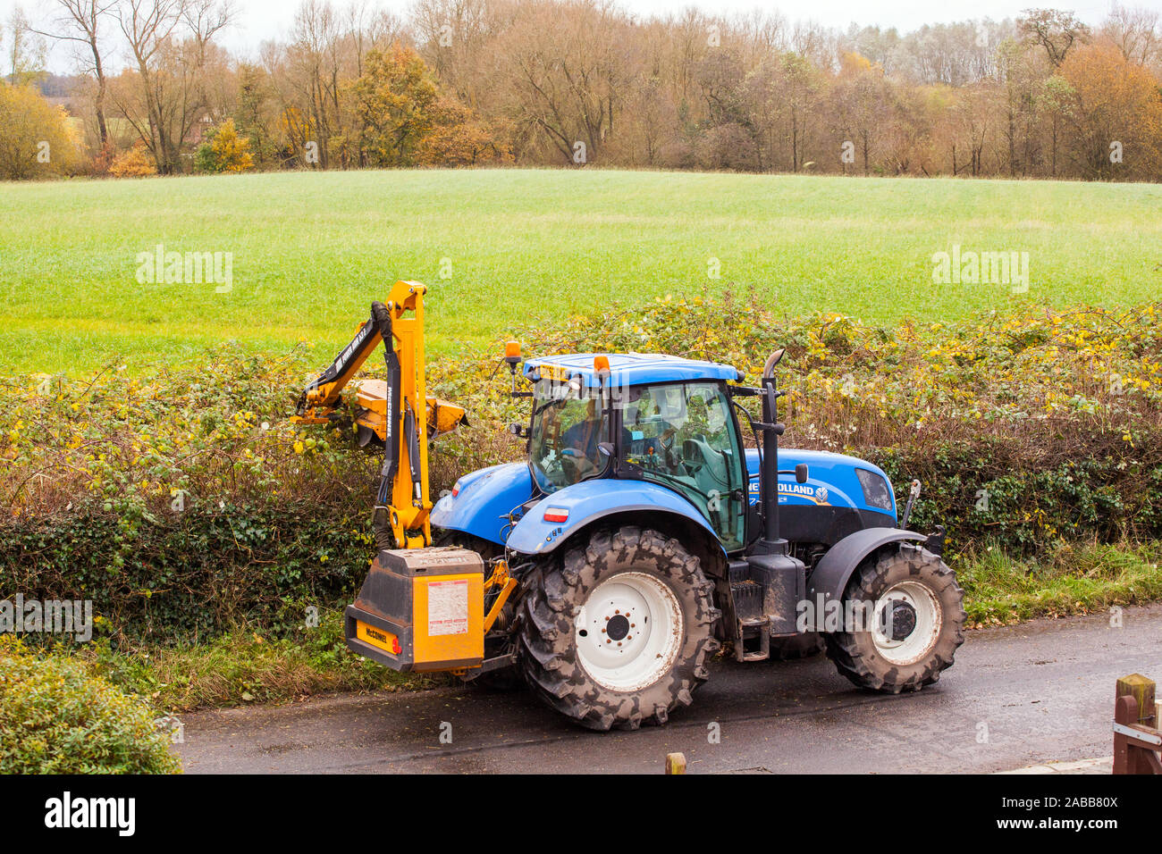 Farm contractor farmer driving a tractor hedge cutting during the Autumn with a McConnel hedge cutter Stock Photo