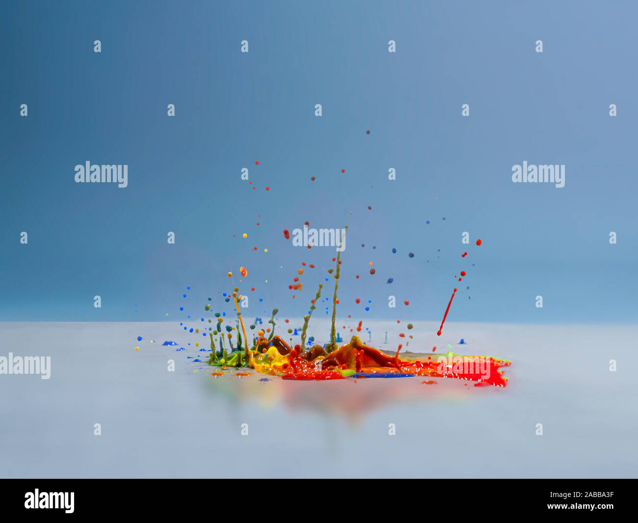 Multi coloured acrylic paint splashing on a surface Stock Photo - Alamy