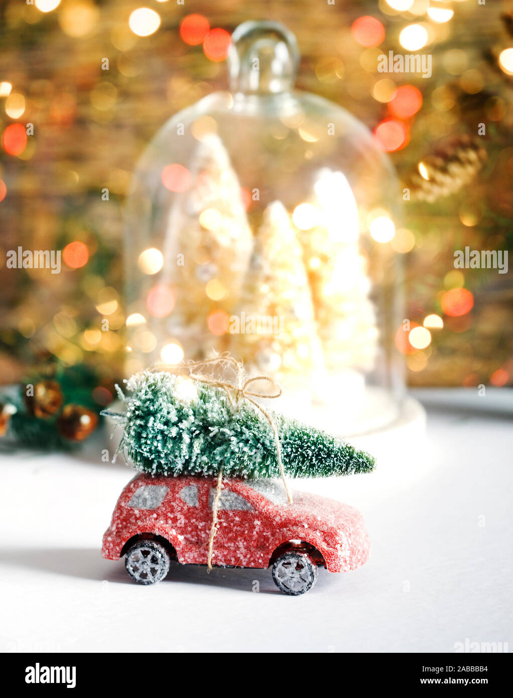 Christmas decoration in a domed tray next to a toy car with a Christmas tree on the roof Stock Photo