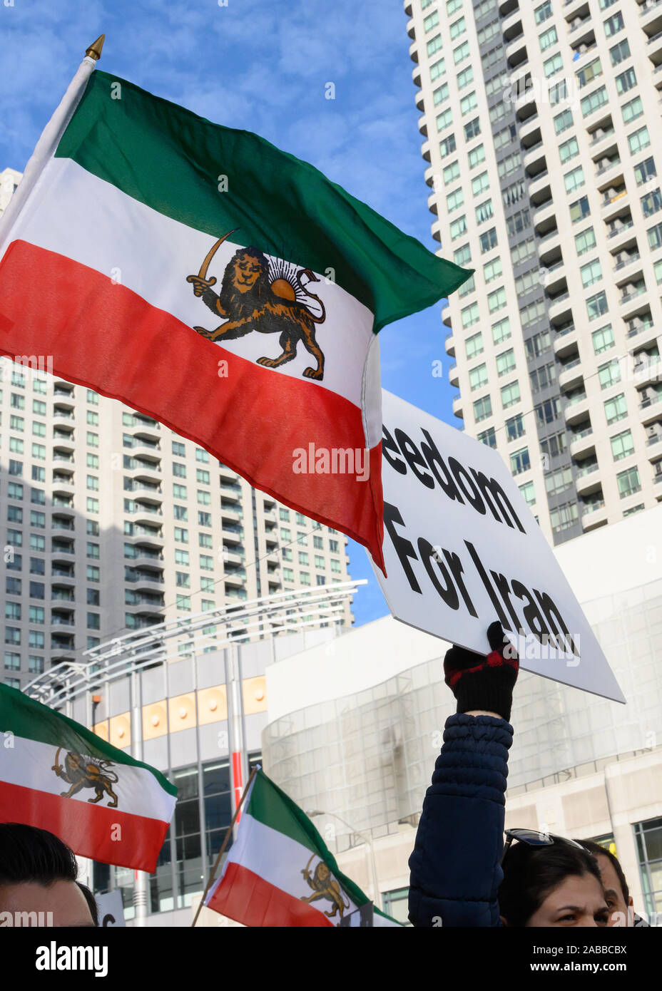 Torontonians gather at Mel Lastman Square to show support for the protesters in Iran while condemning the regime, while a pre-revolution flag waves. Stock Photo