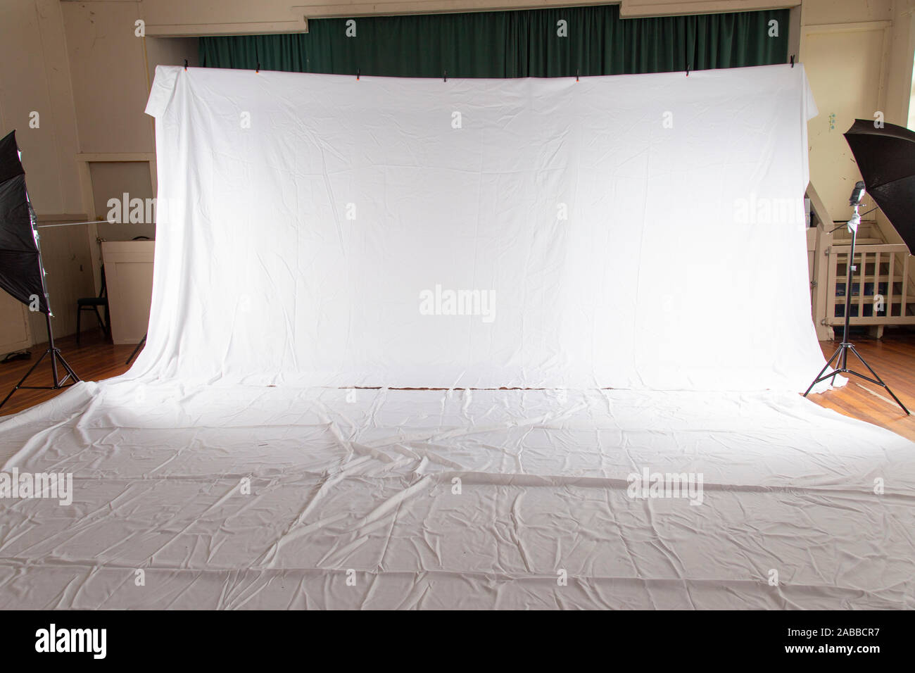Pull back of set up for professional photography shoot. Volume portrait session. White muslin backdrop 6 metres wide by 3 meters long. Floor covered Stock Photo