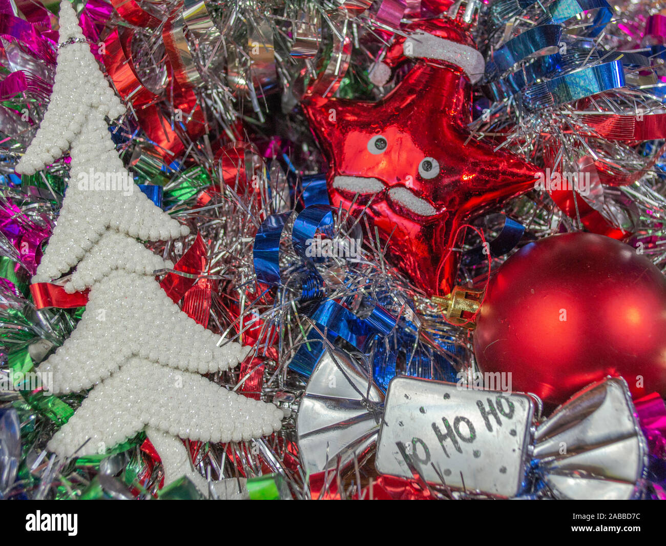White Christmas tree and ornaments on multicolored tinsel in background, photo-illustration Stock Photo