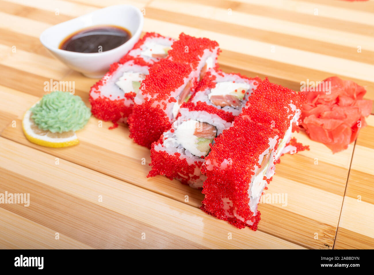 California roll with red flying fish caviar, with wassabi and ginger. Stock Photo