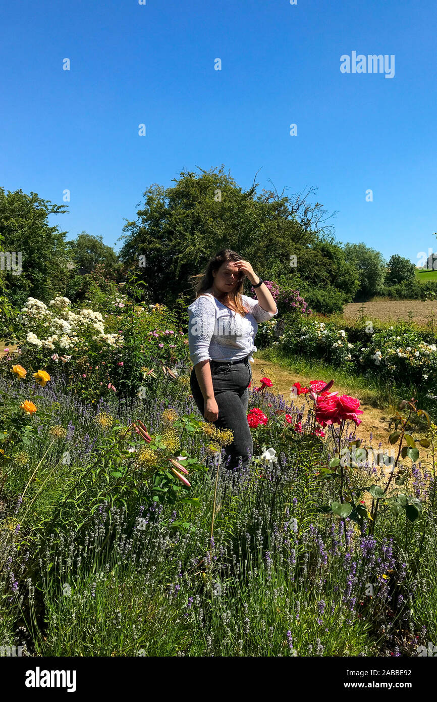 Beautiful woman standing in a flower garden, England, UK Stock Photo ...